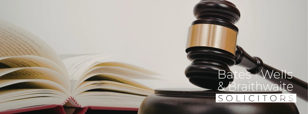 Gavel resting on a desk beside an open book, with the Bates Wells & Brathwaite Solicitors logo in the corner.