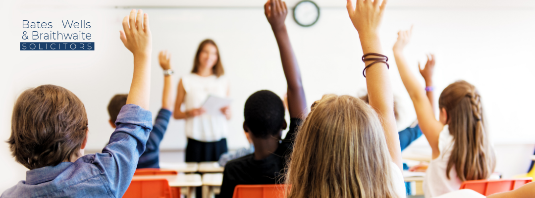 Can I take my child out of school during term time? School Children holding hands up in a classroom